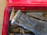 a tool in a red case that is on the floor