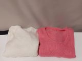 two sweaters sitting on a table next to each other