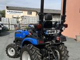 a blue tractor parked in front of a building
