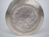 a silver plate with a picture of a man riding a horse on it