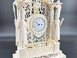 a white clock that is sitting on a table