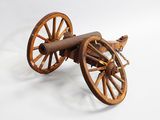 an old wooden cannon sitting on top of a white surface