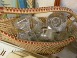 un panier en osier rempli de verres vides posé sur une table