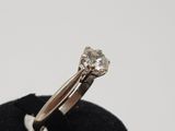 an image of a diamond ring sitting on top of a black velvet ring holder