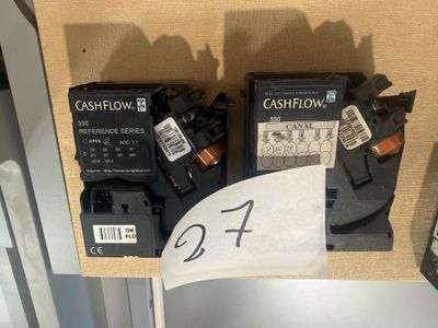 Deux piles noires et blanches sont posées sur une table, à côté d'une télécommande