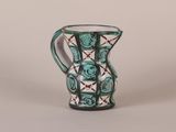 a green and white vase sitting on a table