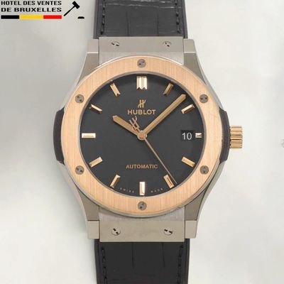 the watch is black and gold with a black dial