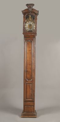 une grande horloge de parquet en bois surmontée d'un oiseau