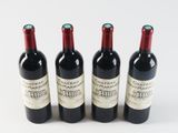 three bottles of red wine are lined up on a white surface