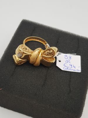 un gros plan d'une bague en or ornée d'un nœud
