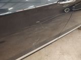 a car that has a broken door handle on the side of it