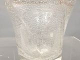 un vase en verre posé sur une table transparente