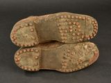 two pairs of shoes with studded soles on a black surface