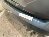 a sticker on the bumper of a car that is parked in a parking lot