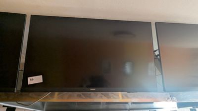 two flat screen televisions sitting on top of a shelf