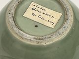 a green vase that has a label on it