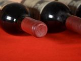 several bottles of wine are lined up on a red cloth
