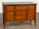 a wooden chest of drawers with a marble top