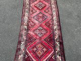 un tapis rouge et rose orné d'un motif en losanges