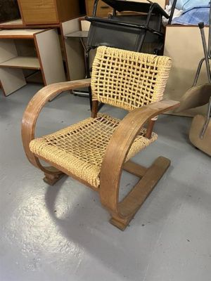 une chaise en bois et en osier posée à même le sol