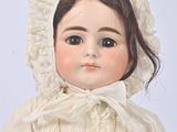 a doll that is wearing a white dress and bonnet