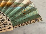 a close up of a hand fan with designs on it