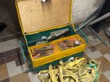 une caisse remplie de bananes posée par terre à côté d'une grappe de bananes