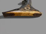 a close up of a wooden gun on a gray background