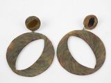 pair of large wooden earrings with a circular design and a wooden bead