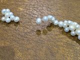 a close up of a bracelet with pearls on it