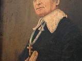 un vieux tableau représentant un homme en manteau noir tenant une croix