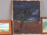 three paintings on a shelf next to two framed pictures