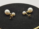 un gros plan sur une paire de boucles d'oreilles en perles posées sur une surface noire