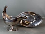 an antique silver plate with a peacock on it next to a silver plate