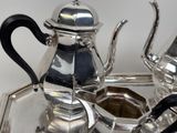 a silver tray with a silver tea pot and a silver tea pot