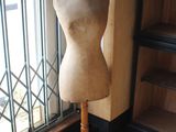 a mannequin on a stand in front of a window