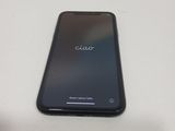 the back of a black cell phone sitting on top of a white table