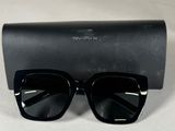 une paire de lunettes de soleil noires posée sur un étui noir
