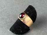 a gold ring with a garnett on top of it