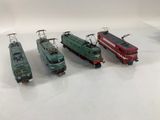 four trains that are lined up on a white surface