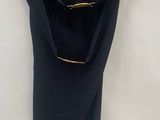 a black dress hanging on a hanger on a white wall