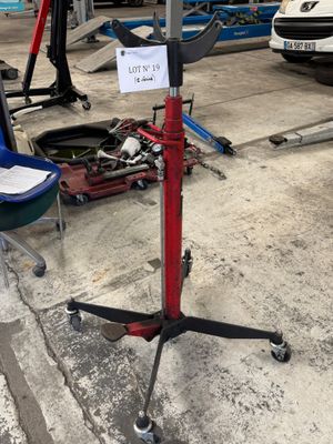 un présentoir rouge et noir sur lequel est accrochée une affiche, dans un garage