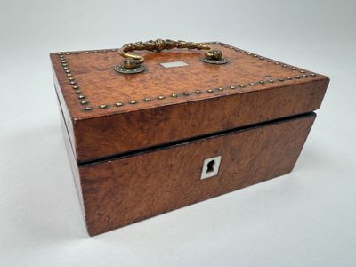 an old wooden box with a ring on top of it