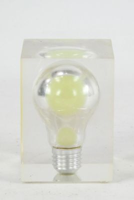 a small light bulb in a clear box on a white surface