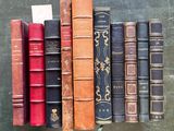 several old books are lined up in a row on a table