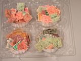 de nombreux timbres de toutes sortes dans une boîte en plastique posée sur une table