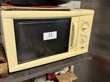 a microwave sitting on top of a shelf in a kitchen