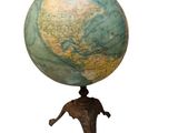 un globe terrestre posé sur un socle, sur fond blanc