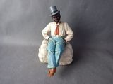 a figurine of a man sitting on a rock