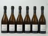 six bouteilles de vin sont alignées sur une table